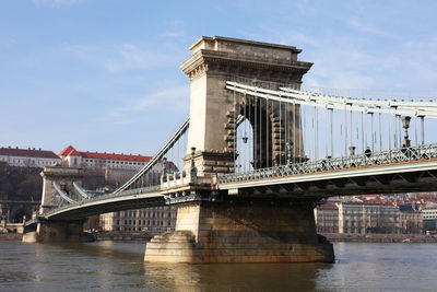 Low angle view of szechenyi chain bridge over river against sky