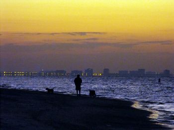 Silhouette of woman in sea at sunset