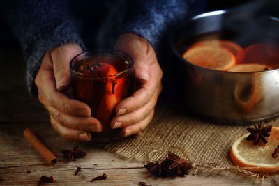 Cropped hands having tea on table during winter