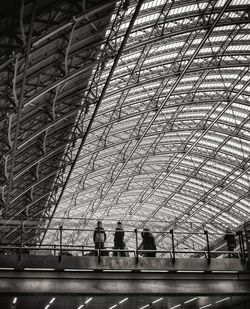 Low angle view of people walking on ceiling