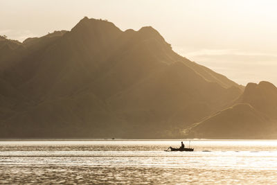 Scenic view of sea and mountains against sky