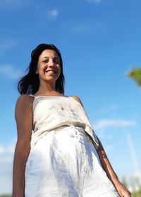 Low angle view portrait of woman standing against sky