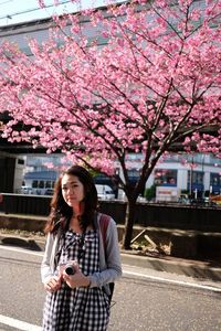 Portrait of smiling young woman standing on road