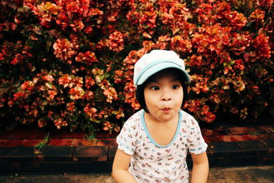 Portrait of cute girl standing against plants
