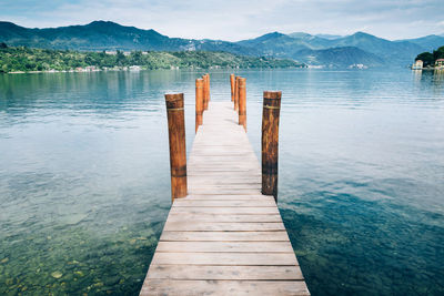 Wooden pier over lake against sky