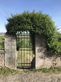 Entrance gate on field against sky