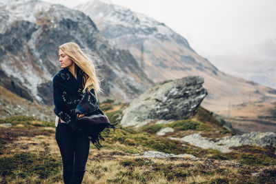 Woman standing on rock against mountain