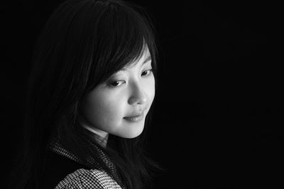 Close-up of smiling woman on black background