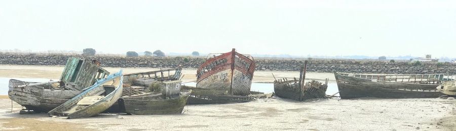 Abandoned boats on beach against clear sky