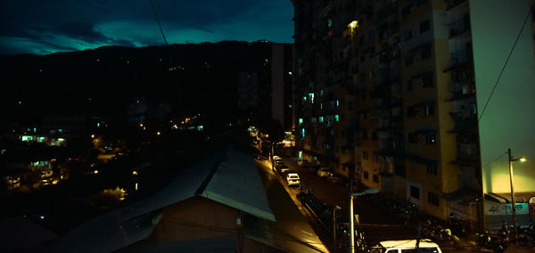 Illuminated cityscape against sky at night