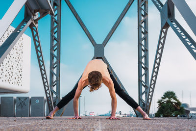 Full length of young woman leaning against built structure