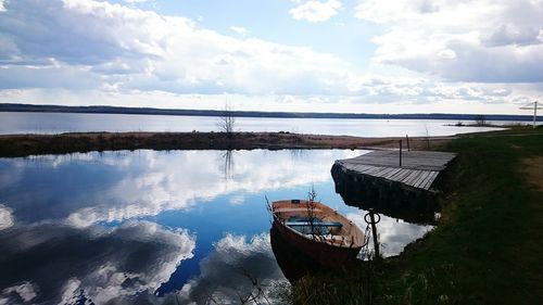 Scenic view of calm lake against cloudy sky