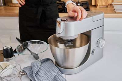 Woman cooking at preparing food, using food processor,