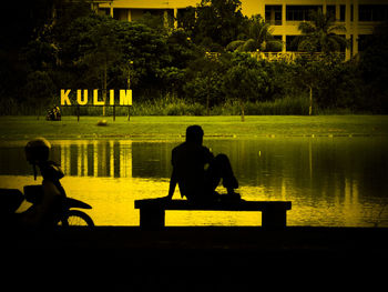 Rear view of men sitting on bench