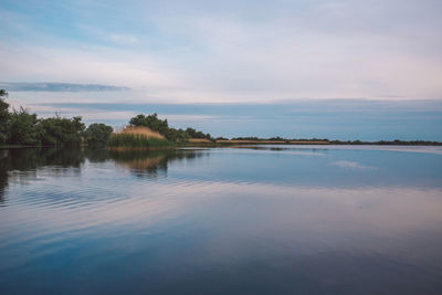 Scenic view of lake against sky at sunset