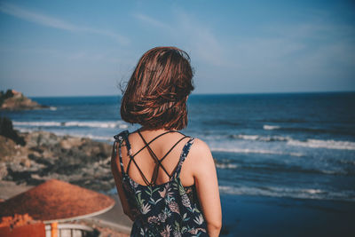 Rear view of woman looking at sea against sky