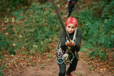 Portrait of young woman standing against plants