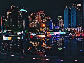 Illuminated cityscape against sky at night