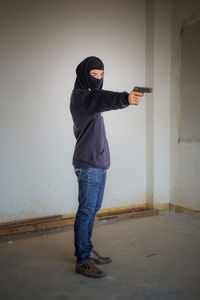 Full length of man standing against wall