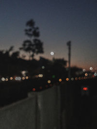 Defocused image of illuminated city against sky at night