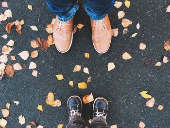 Low section of father and son wearing shoes while standing on road