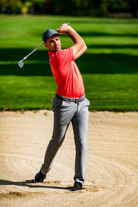 Sand wedge shot, professional golfer playing from a sand bunker