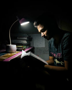 Man studying in dark at home