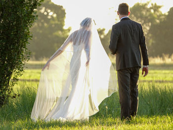 Rear view of couple standing on field