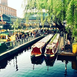 People on street by canal in city