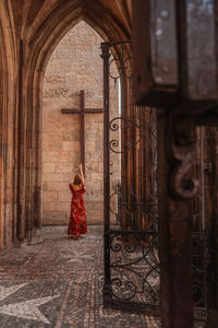 Rear view of woman standing against building