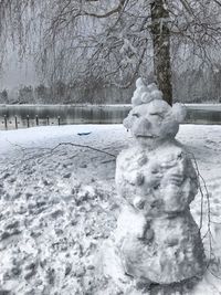 Statue of frozen bare tree against sky during winter