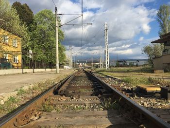 Railroad tracks amidst trees against sky