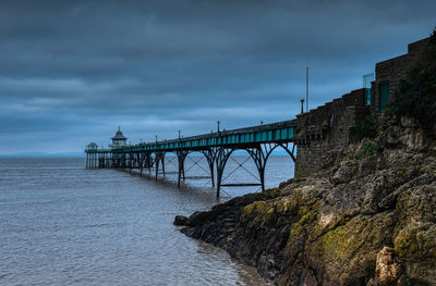 Bridge over sea against sky at dusk