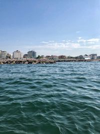 Scenic view of sea and buildings against sky