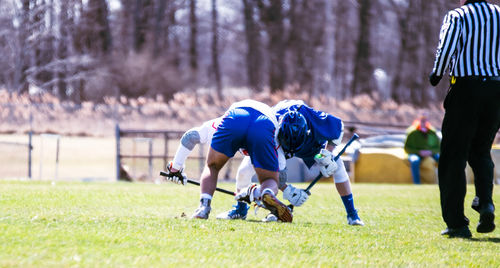 Rear view of people running on grassland