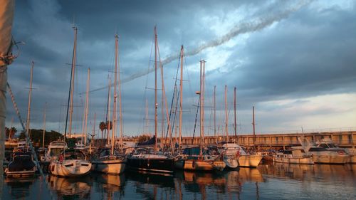 Boats moored at harbor against sky