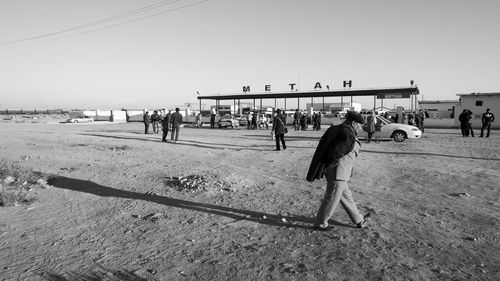 People on beach against clear sky