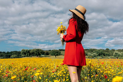 View of woman standing on field against cloudy sky