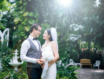 Loving wedding couple standing at backyard