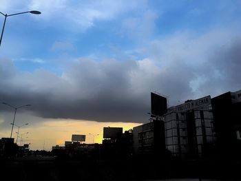 Low angle view of buildings against cloudy sky