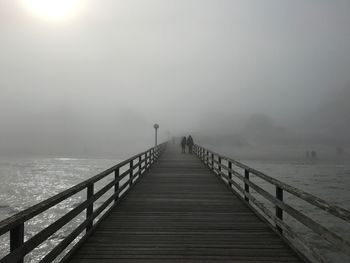Pier over sea against sky during foggy weather