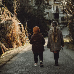 Rear view of women walking on footpath