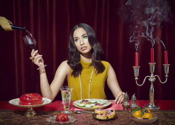 Portrait of young woman sitting on table