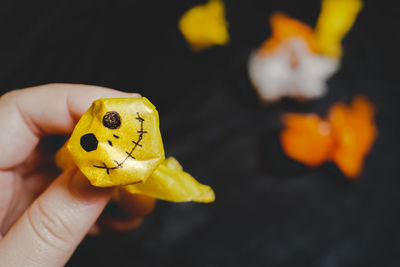 Close-up of person holding yellow leaf