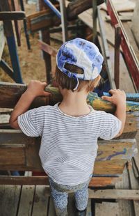 Rear view of boy holding umbrella