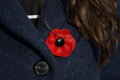 Close-up of red brooch on coat