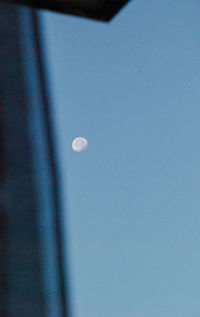 Low angle view of moon against clear blue sky