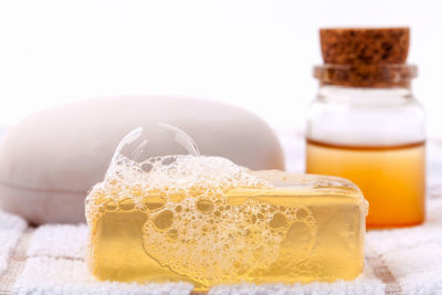 Close-up of soaps on table against white background