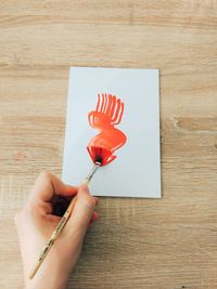 Close-up of hand holding red flower