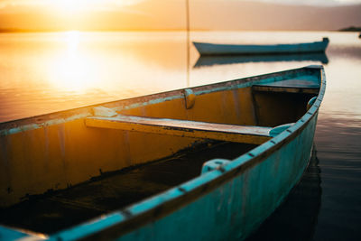 Fishing boat moored in sea during sunset